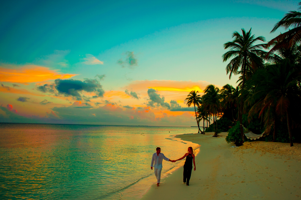 man-and-woman-holding-hand-walking-beside-body-of-water